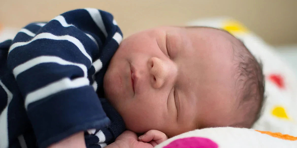 Baby mit gestreiftem Shirt schläft 